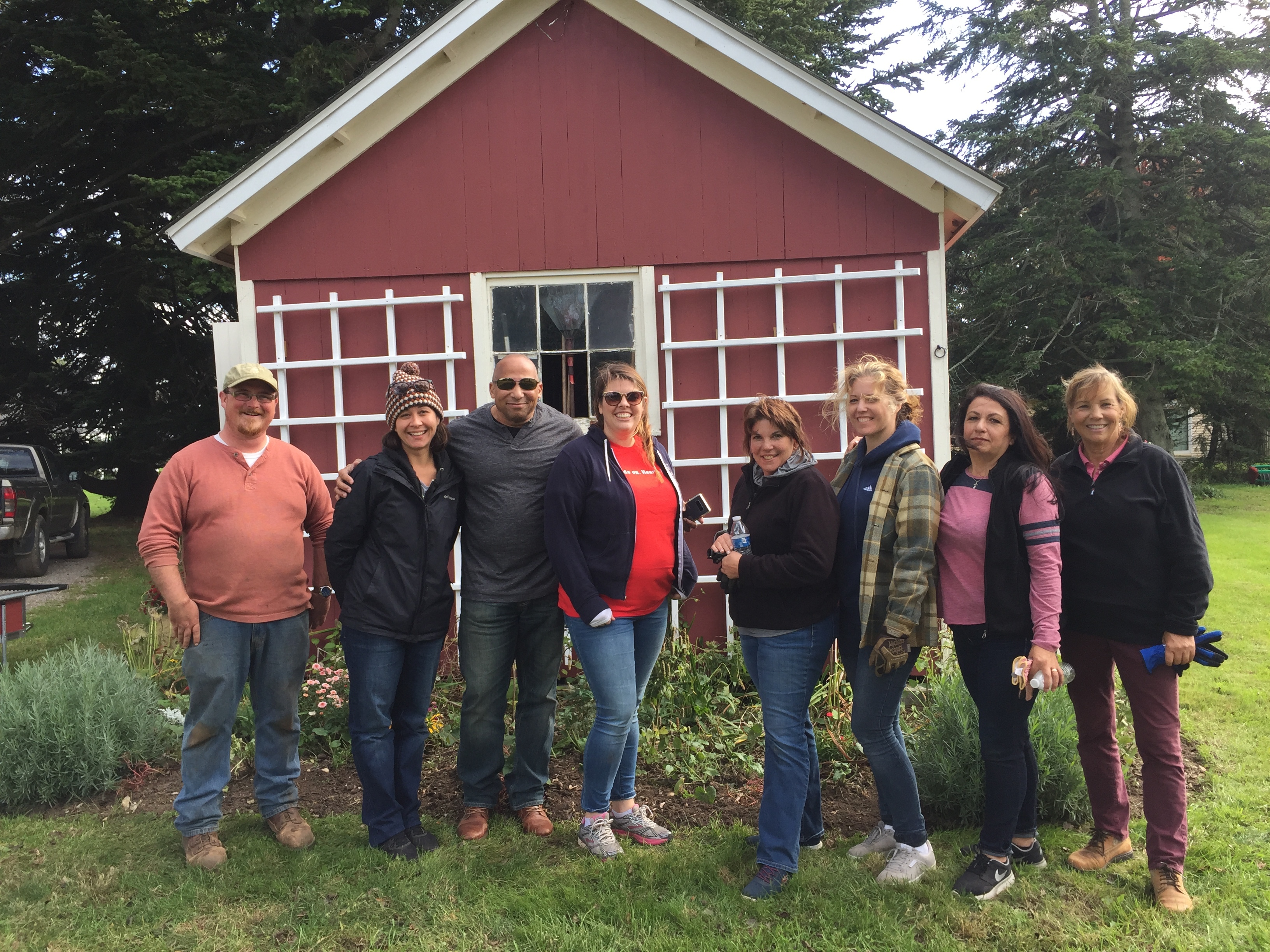 volunteers in front of a red shed