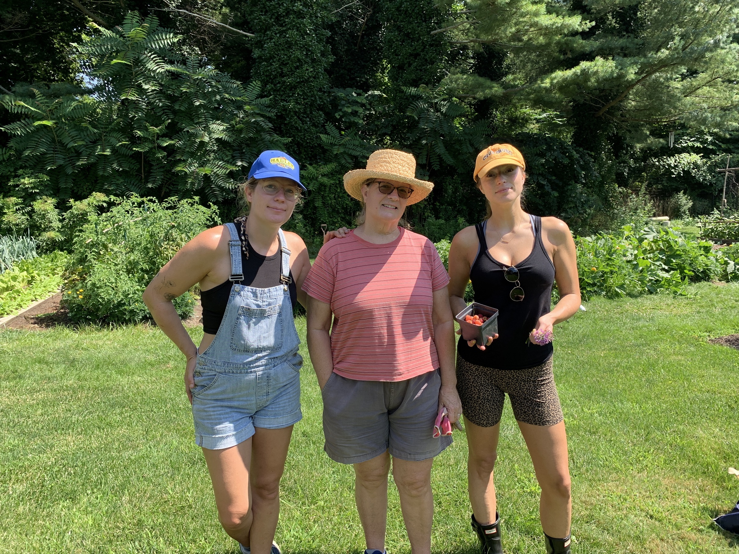 three people standing with vegetables